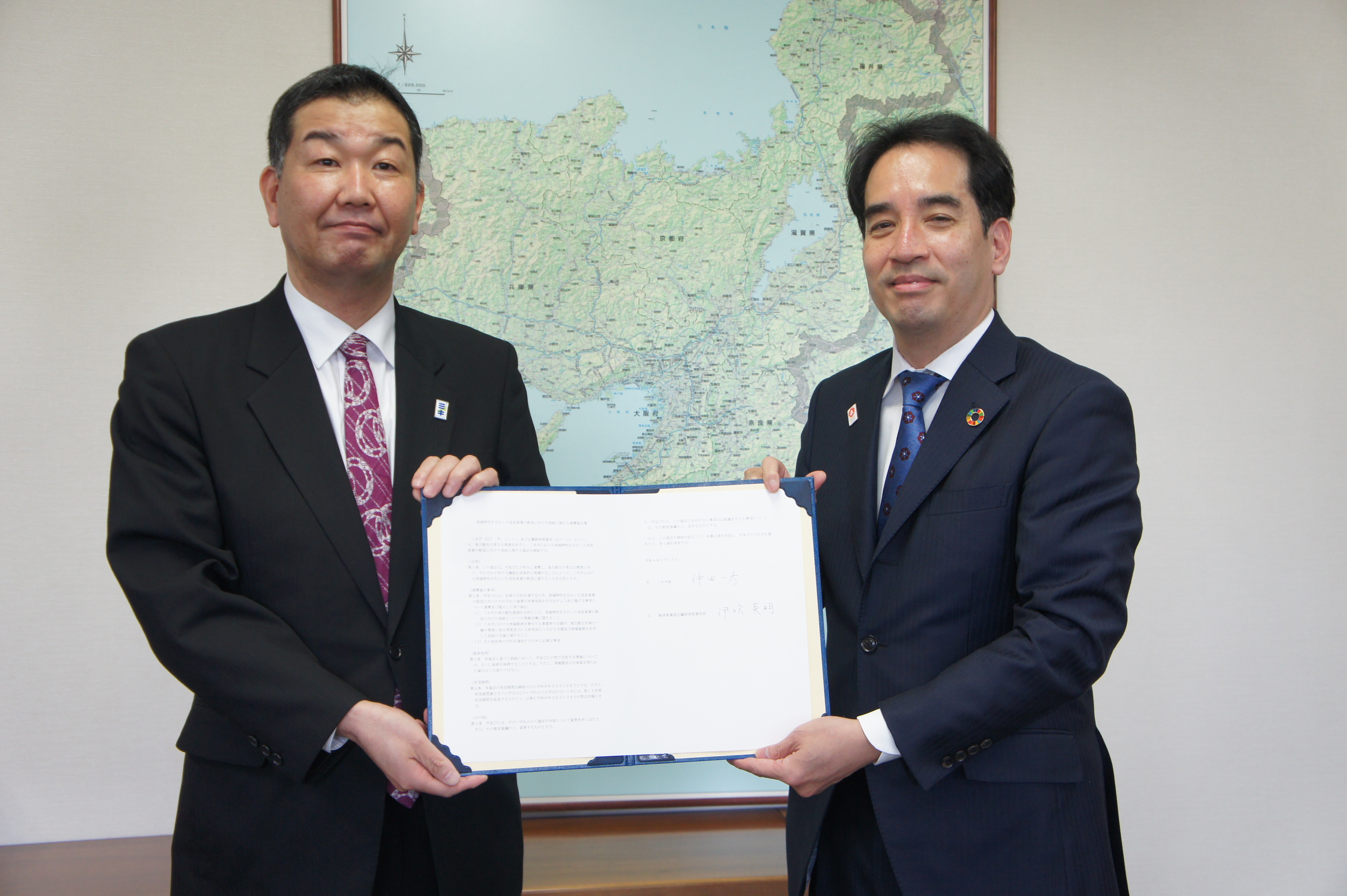 協定書を掲げて記念撮影（左：仲田市長、右：伊吹局長）